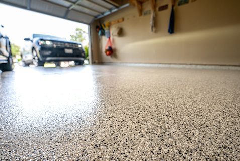 speckled garage floor coating with car in the background